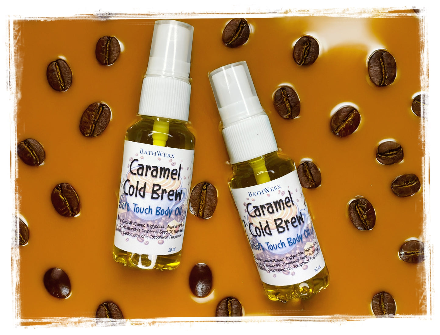 Two bottles of Caramel Cold Brew body oil surrounded by coffee beans on a brown background