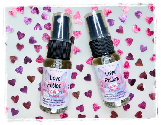 Two bottles of 'Love Potion' hair and body dry oil on a heart-patterned background