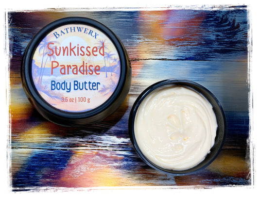BathWerx Sunkissed Paradise Body Butter open tin showing creamy white texture on colorful sunset-toned wood surface