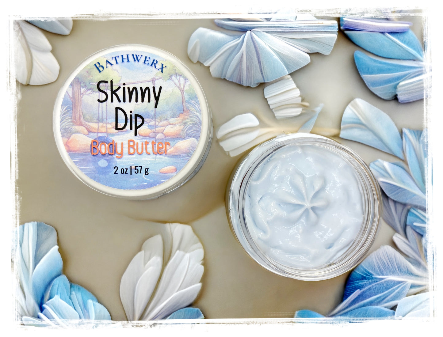 BathWerx Skinny Dip Body Butter open clear jar showing creamy white texture, surrounded by blue and white paper fan decorations