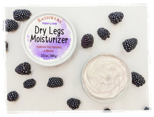 2 pots of dry leg moisturizer on a white background with scattered black raspberries.