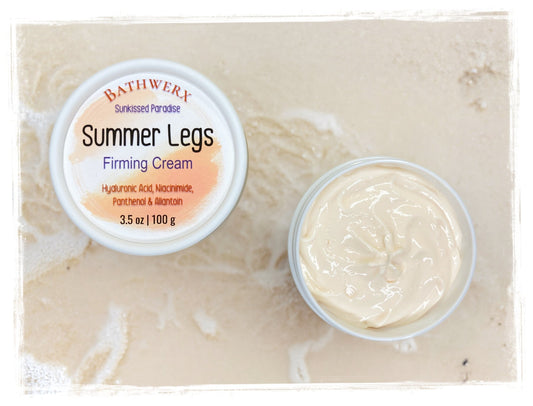 Tub of light orange body butter cream with tropical fruits and lush green leaves on a sunny yellow background – BathWerx Summer Legs Firming Cream