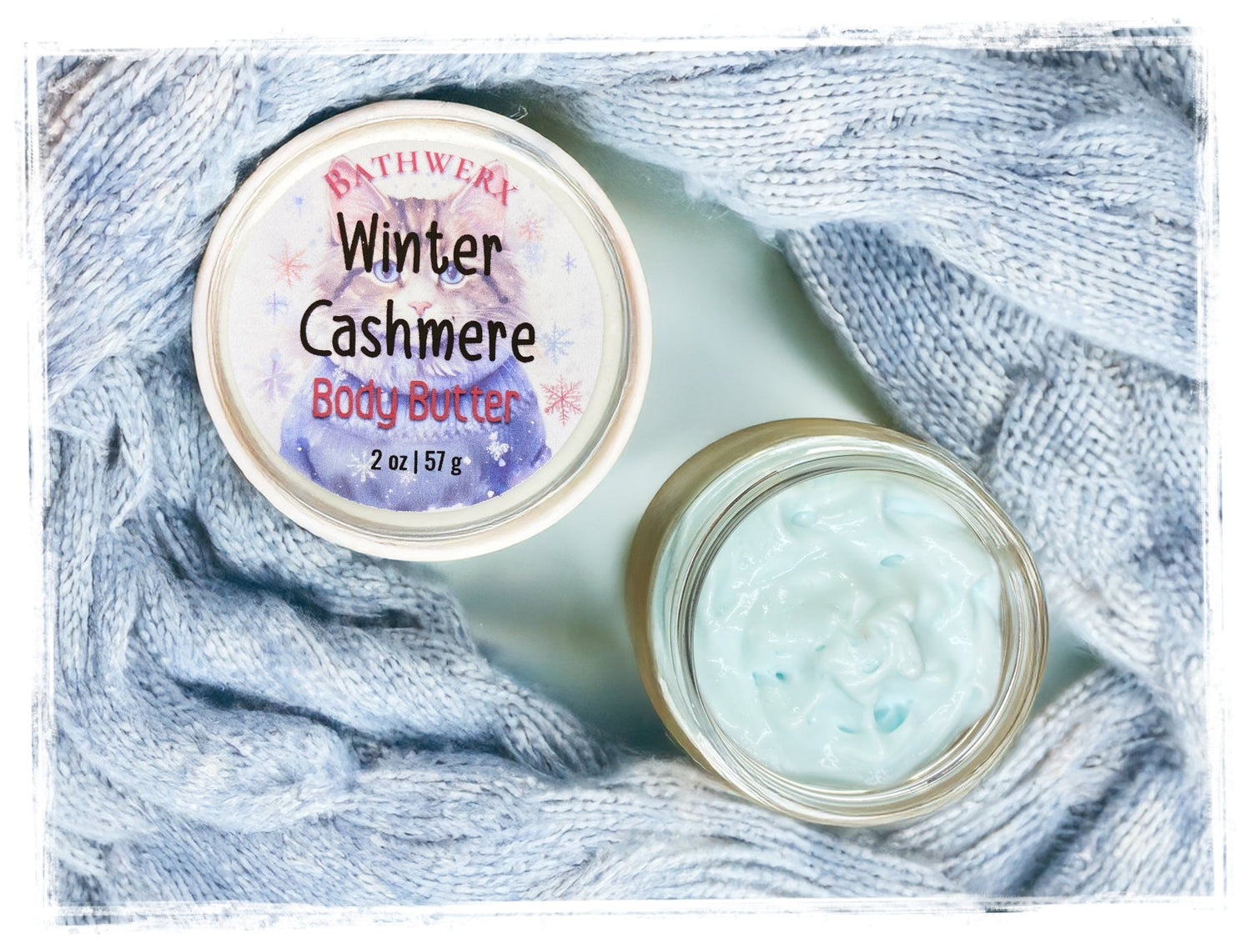 Two jars of Winter Cashmere body butter on blue textured background