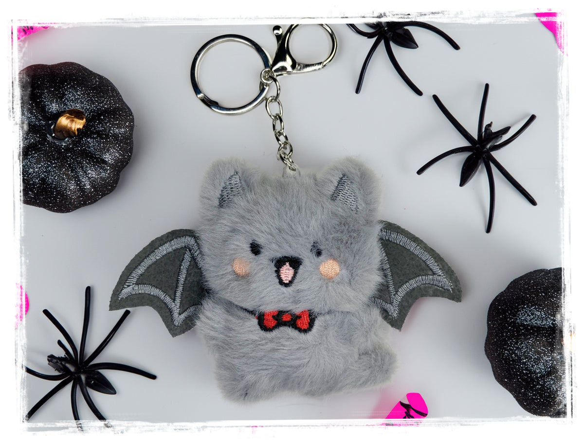 Gray plush bat keychain with metal key ring and clasp.