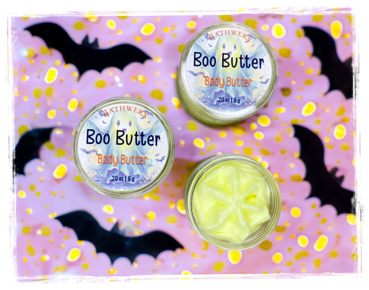 Boo Butter body butter jars, including an open jar of pale yellow butter, on a purple Halloween background with bats and gold confetti.