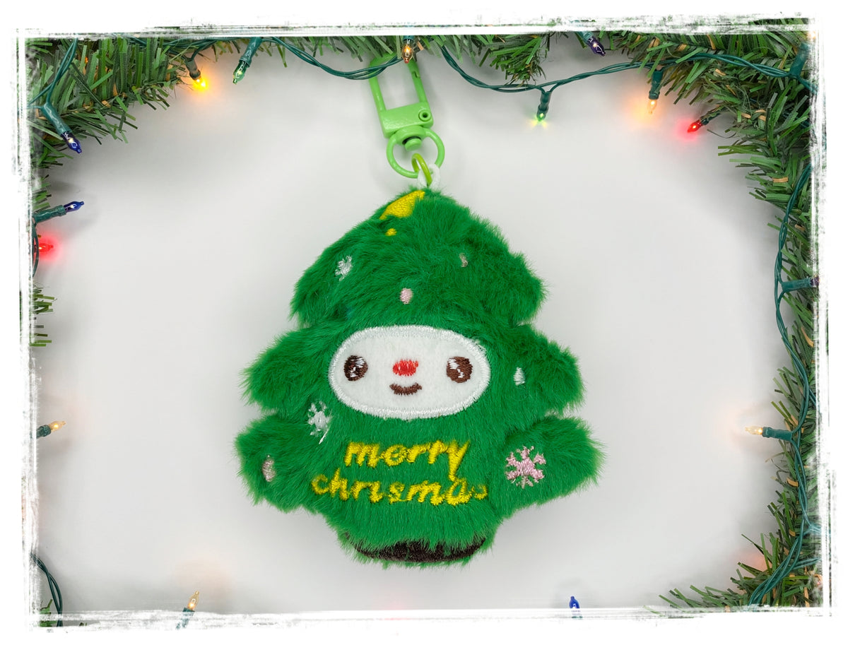 Green Christmas tree plush keychain with embroidered “Merry Christmas” text.