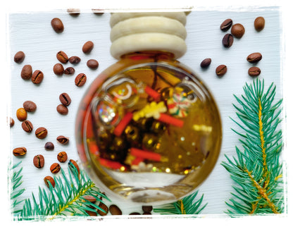 Peppermint Mocha car charm air freshener in a round glass bottle, styled with coffee beans and evergreen sprigs.