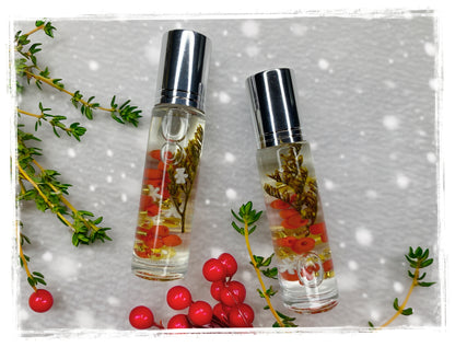 Two Christmas Thyme roll-on perfume oil bottles with silver caps and botanical accents, surrounded by thyme sprigs and red berries.