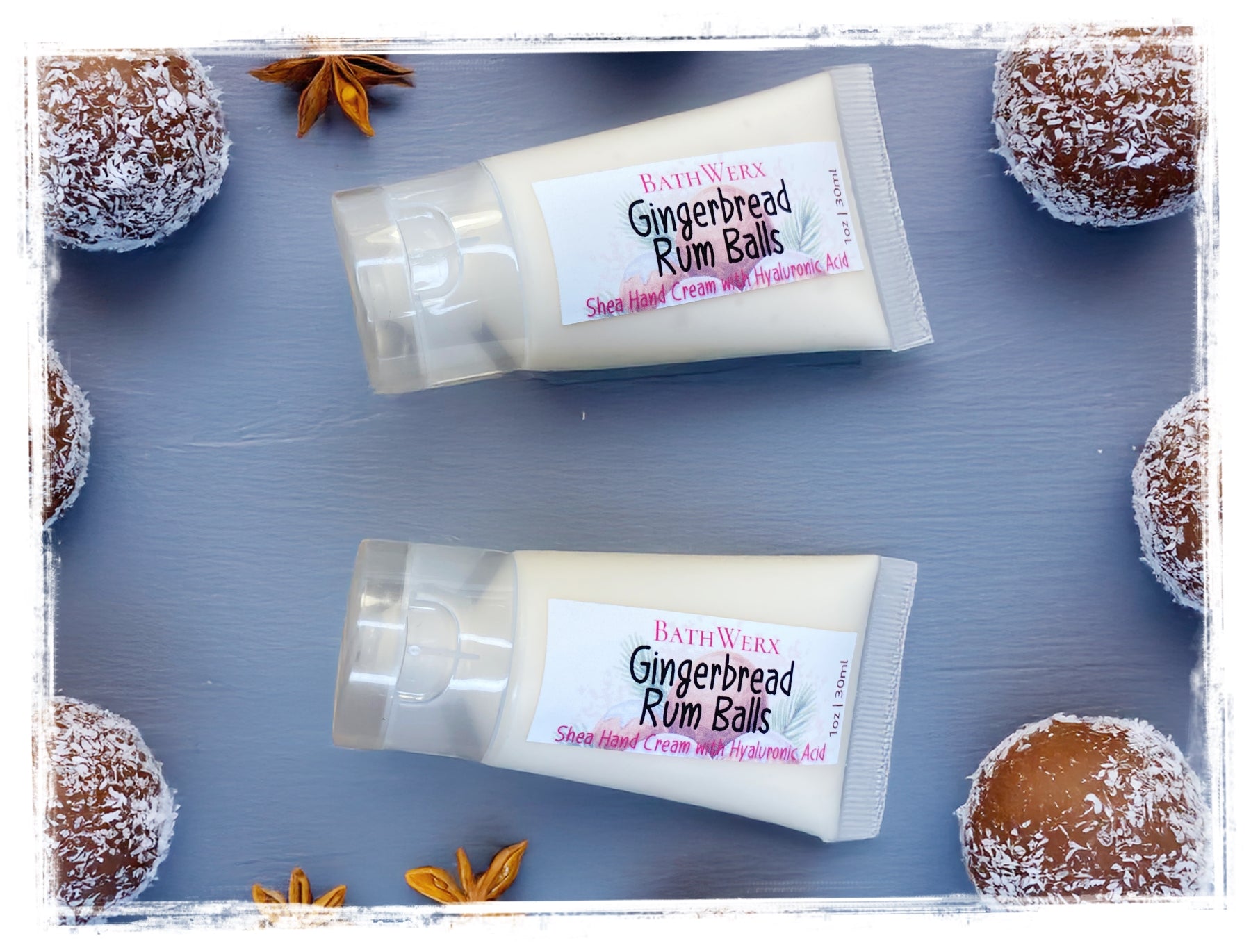 Two tubes of Bath & Body Works Gingerbread Rum Balls shea hand cream on a blue surface with gingerbread cookies.