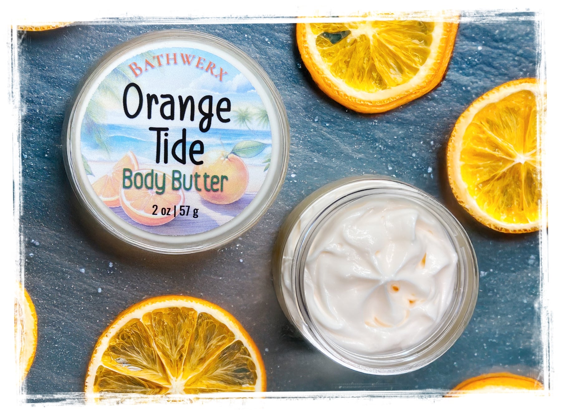 Orange Tide body butter jar with slices of orange on a blue background