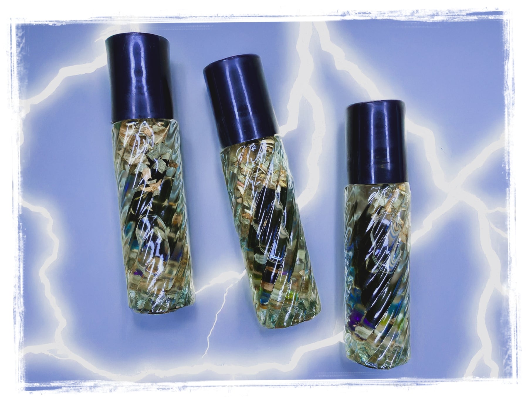 Three small roll-on bottles with black caps on a blue background that contain the product Storm Relief.
