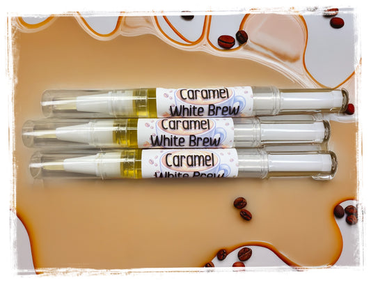 Three Caramel White Brew coffee cuticle nail pens on a caramel-themed packaging background.