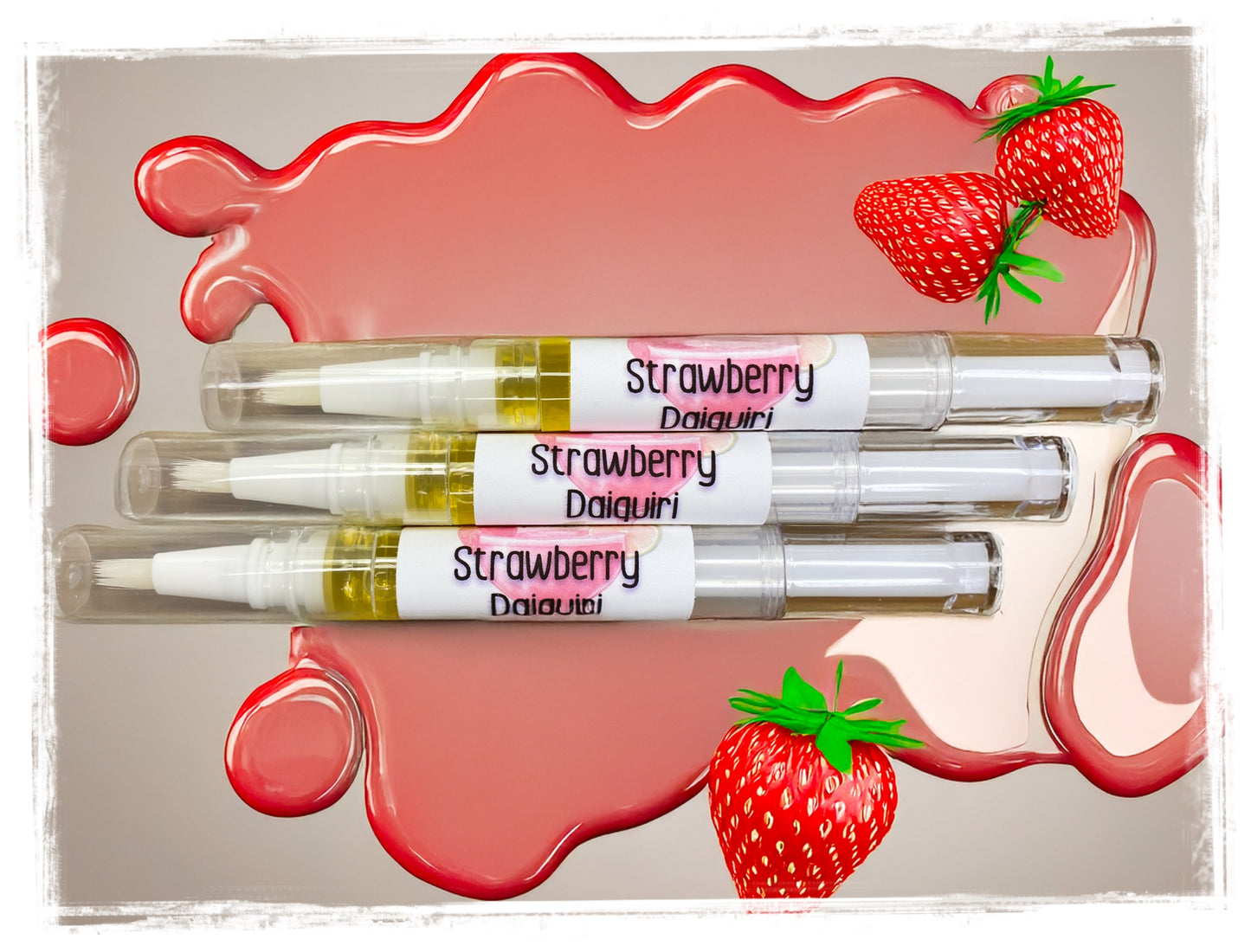Three Strawberry Daiquiri-flavored cuticle nail pens with strawberry graphics on a pink and beige background.