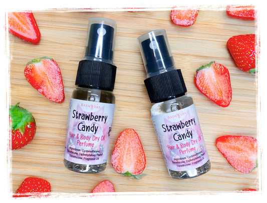 Two bottles of Strawberry Candy hair and body dry oil on a wooden surface with strawberries.