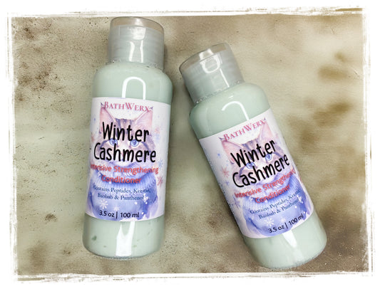 Two bottles of Bath & Body Works Winter Cashmere hair conditioner product on a textured surface