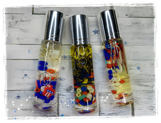 BathWerx 4th of July Roll-On Perfume Oil — three clear bottles filled with red, white, and blue patriotic charms and beads