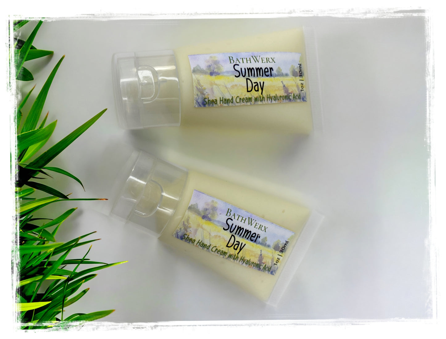 BathWerx Summer Day Shea Hand Cream two tubes on white surface with lush green tropical leaves