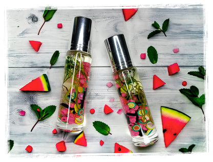 BathWerx Watermelon Mint roll-on perfume with fruit charm-filled clear oil, flatlay with watermelon and mint