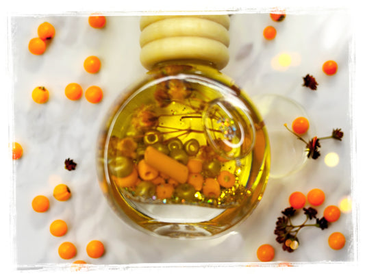 Toasted Pumpkin Spice car charm – round glass bottle with golden oil and orange botanicals on marble