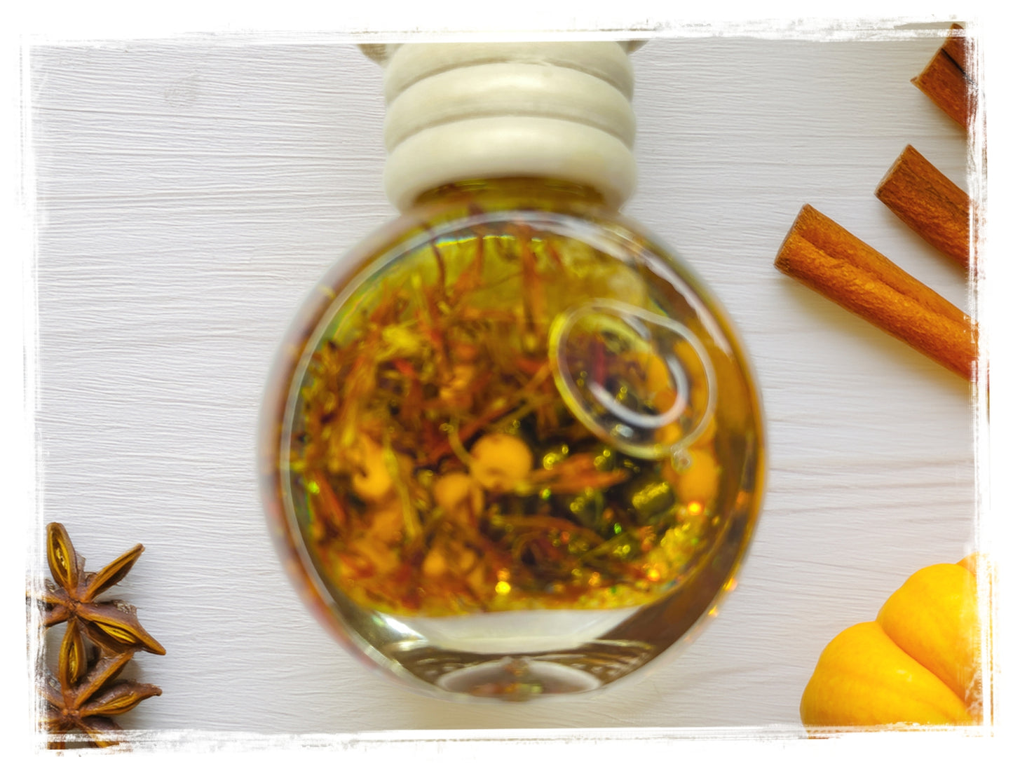 Pumpkin Chai Fall Scented Car Charm with golden botanical oil in a round glass bottle styled with cinnamon sticks, star anise, and pumpkin