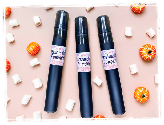 BathWerx Marshmallow Pumpkin perfume sprays in matte black, styled on a blush pink background with mini pumpkins and marshmallows - travel-size 10ml fall fragrance.
