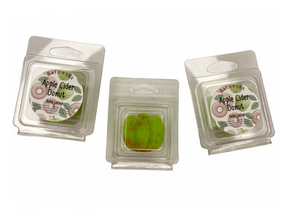 Three BathWerx Apple Cider Donut Solid Lotion bars in clear clamshell packaging with branded labels, center bar shown revealing a green speckled lotion bar - .5 oz.