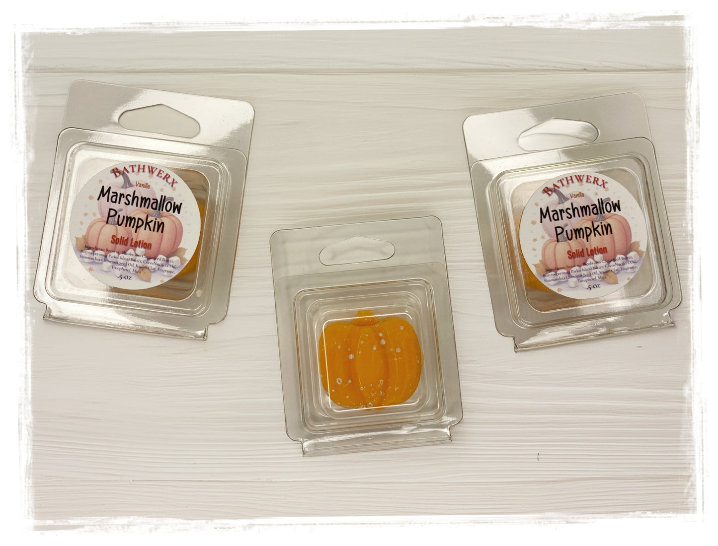 BathWerx Vanilla Marshmallow Pumpkin Solid Lotion bars in clear clamshell packaging, center bar shown unwrapped revealing a vibrant orange lotion bar - .5 oz.