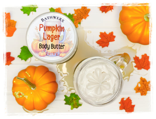 BathWerx Pumpkin Lager Body Butter 2 oz in a glass jar, surrounded by orange pumpkins and fall maple leaves on a white background.