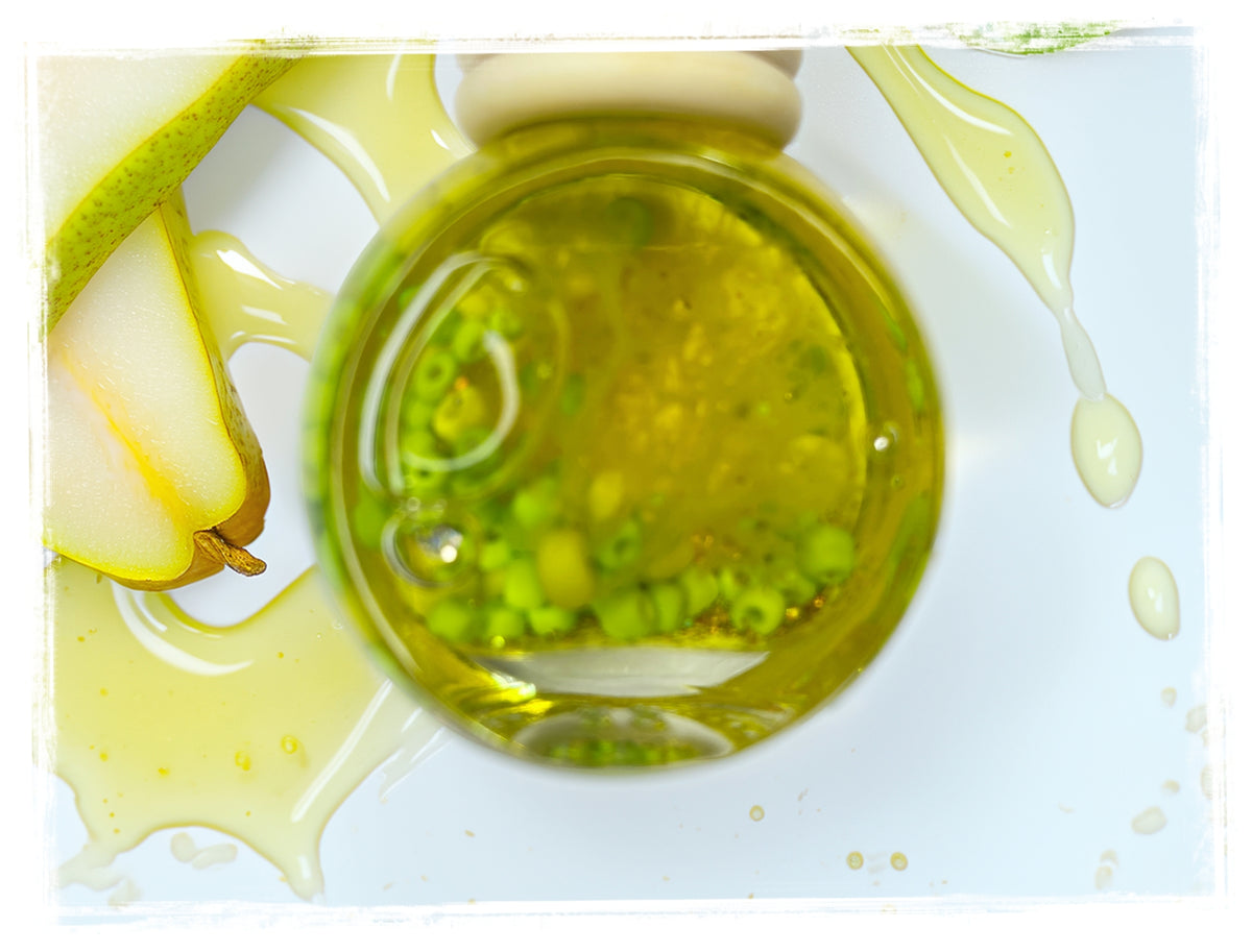Honey Spiced Pear car charm — round glass oil bottle with golden-green liquid and fresh pear slice