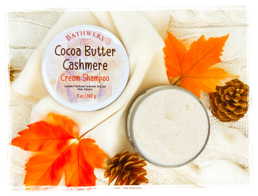 BathWerx Cocoa Butter Cashmere Cream Shampoo surrounded by fall maple leaves and pinecones on a cozy knit background.